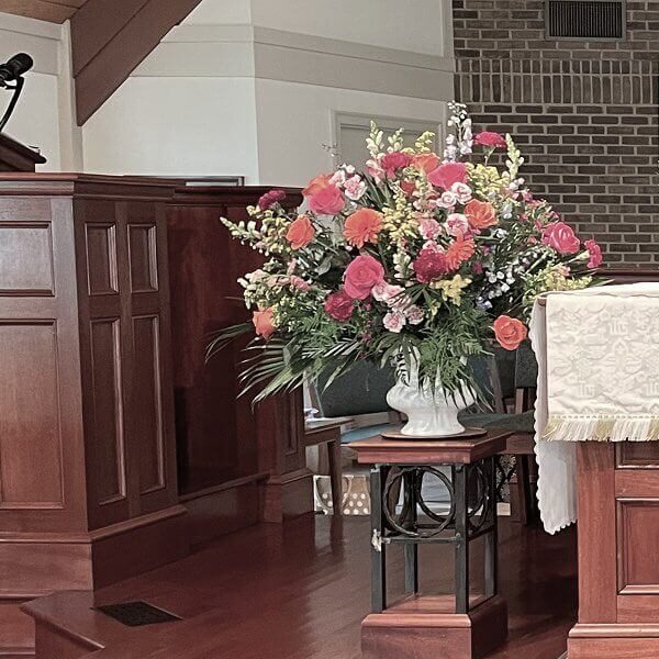 A wooden altar with a white cloth inscribed 'Alabados' in a church.