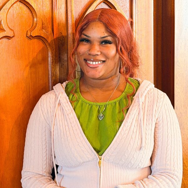 Smiling woman with red hair by wooden door
